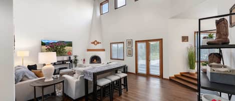 "Spacious and Inviting Living Room with High Ceilings and Modern Decor in Stylish Home - Perfect for Family Comfort and Entertaining Guests"