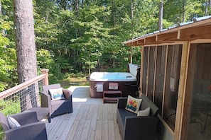 Private deck facing the woods to enjoy the hot tub at Plum Nelly