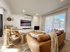 Lounge area with large leather couch and Samsung Art TV