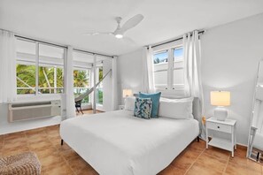 The master bedroom at Palm Beach Villa is a tropical retreat with a king size bed and balcony.