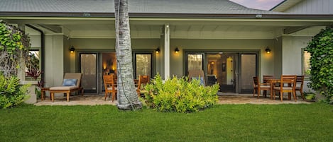 Outdoor patio with furniture, enjoying the green lawn while hearing the waves.