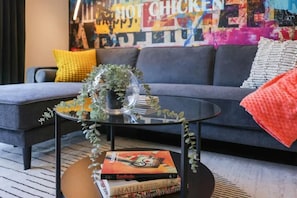 Chaise lounge sectional sofa and coffee table with custom wallpaper mural.