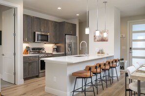 Fully Stocked Chefs Kitchen With An Oversized Island That Includes Bar Seating For 4 People