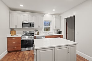 Unit #1 (1 of 3,  Ground Floor) Cook up a feast in this modern kitchen featuring stainless steel appliances and a spacious island. 🍽️👨‍🍳✨