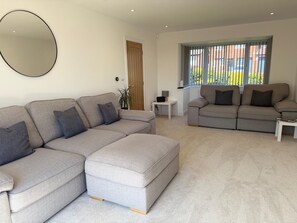 Living room with 75" TV and comfy sofas