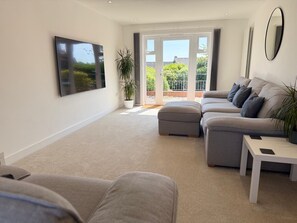 Living room with 75" TV and comfy sofas
