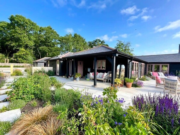 Welcome to 'The Artists Barn,' a secluded five-bedroom, four-bathroom retreat in ancient bluebell woodland bordering the South Downs National Park.