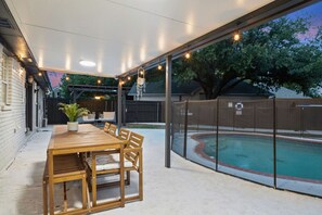 Enjoy a meal outdoors with a beautiful poolside view.