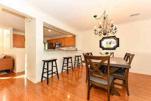 Dining area with bar sitting at kitchen counter.