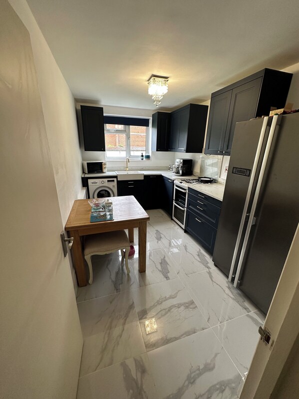 Kitchen, dishwasher, washing machine and American fridge freezer, dining table