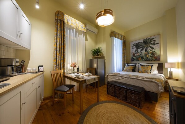 Spacious area featuring a fully equipped kitchen, dining table, and a comfortable bed, all set against a backdrop of lush, vibrant jungle-themed decor.