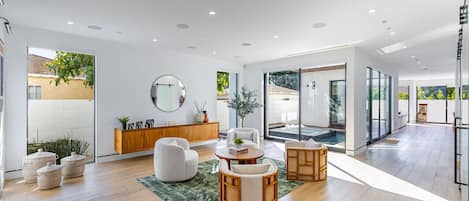 Throughout the first floor, floor-to-ceiling sliding windows drench the home in natural light, and seamlessly blend the home’s indoor and outdoor areas. Custom window shades throughout offer privacy.
