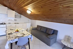 The living area with a kitchen, dining table and sofa