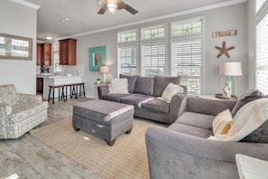 Unwind in style! The living room bathed in natural light, adorned with plush couches and a smart TV, invites you to kick back, relax, and enjoy your retreat to the fullest