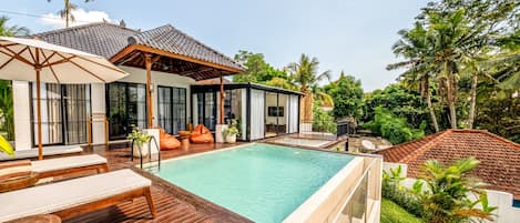 The villa stands on a hilltop overlooking lush rice fields and jungle.