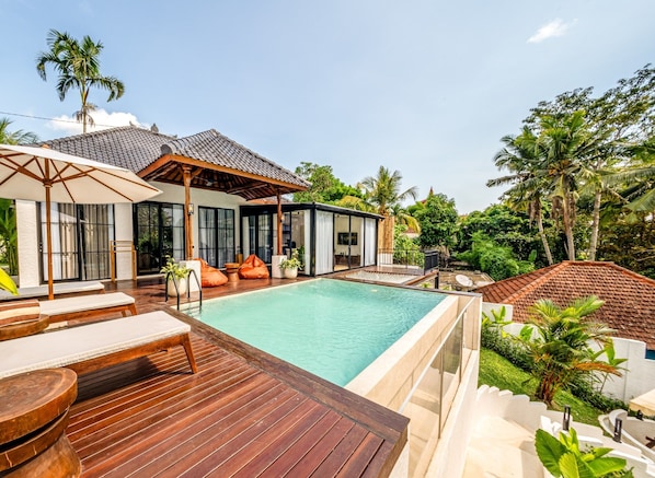 The villa stands on a hilltop overlooking lush rice fields and jungle.