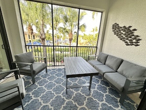 Enjoy your private balcony with plush seating overlooking the vibrant pool area — the perfect spot for your morning coffee. #MorningBliss #BalconyViews #NaplesCharm