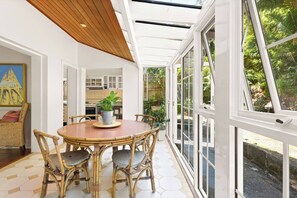 The light-drenched dining area is complete with a four-seater table and tranquil garden views. 
