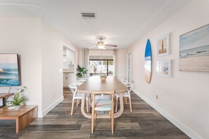 Gather around a coastal-inspired bright dining table with ample seating, perfect for shared meals and relaxed conversations