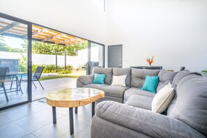  cozy living room with large windows looking out onto the pool.