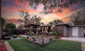 Outdoor living space. Equipped with outdoor smart TV, outdoor dining table & chairs, lounge area, firepit, outdoor grill & more