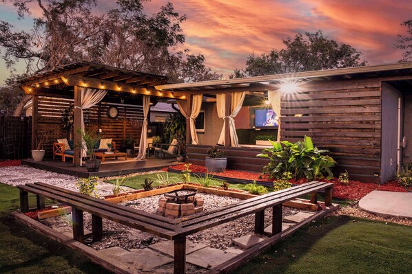 Outdoor living space. Equipped with outdoor smart TV, outdoor dining table & chairs, lounge area, firepit, outdoor grill & more