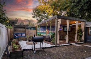 Outdoor living space full with seating, fire pit, Grill, Smart TV, etc.