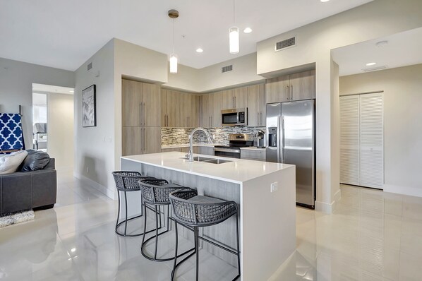 Our modern kitchen features stainless steel appliances and contemporary cabinetry with quartz counter tops