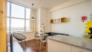 Overview of our spacious living area, with a comfortable couch, table for two and a big window that brightens the whole space #bright #modern