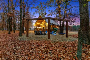 Family-friendly Broken Bow cabin with swing set and forest views.