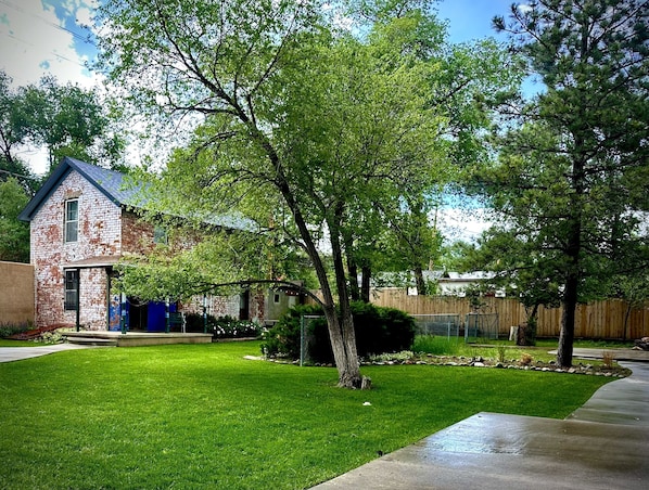 The Carriage house sits at the back of the property in the shaded, grassy lawn.