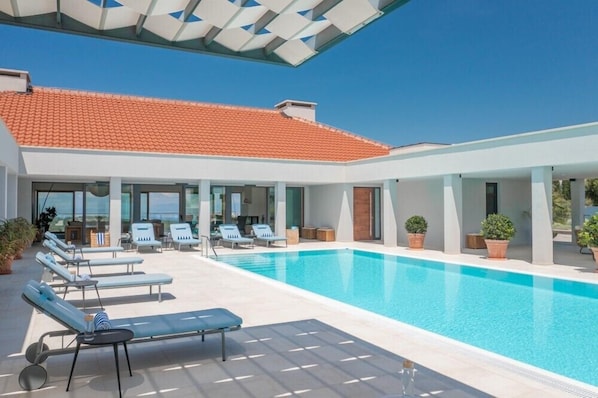 Terrasse der neu erbauten Familienvilla zur Miete Brachia 1 mit privatem Pool, umgeben von Sonnenliegen auf der Insel Brac