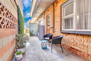 A paved outdoor area at the back of the apartment creates a private space where you can enjoy some fresh air.
