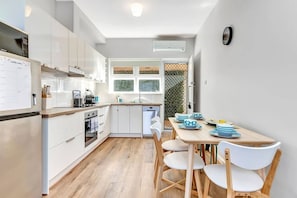 There is a four-person dining table within the kitchen, where you can sit down to your morning coffee or come together for a shared meal at home.
