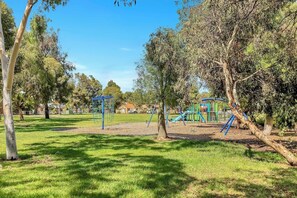 A children's playground and nature reserve sits behind the house for some family fun. 
