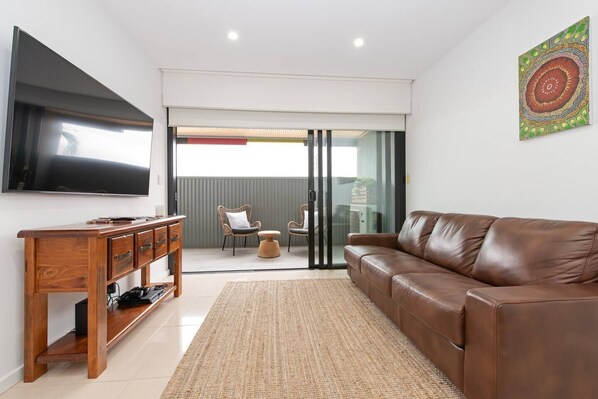 In the living room, kick back on the comfy leather sofa and enjoy a movie on the large wall mounted 65" Samsung TV.