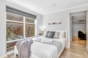 The bedroom features a queen bed and has a private, leafy outlook.
