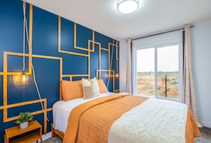 Comfortable and stylish bedroom with a Queen-sized bed and soft, inviting boho decor