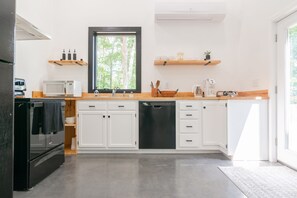 Full kitchen with essentials including: blender, coffee machine, pots, and pans