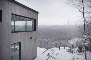 Vu de côté du chalet avec vue sur le pit à feu extérieur