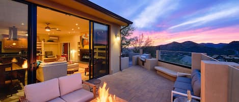 Private side patio offering stunning valley and mountainous views featuring a built-in BBQ grill, and a fire pit with outdoor furnishings.