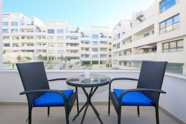 Lovely terrace with outdoor dining area for two guests and pool views