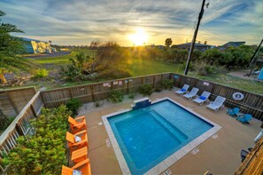 Beautiful backyard with a pool, large patio, and balcony with stunning sunset views.