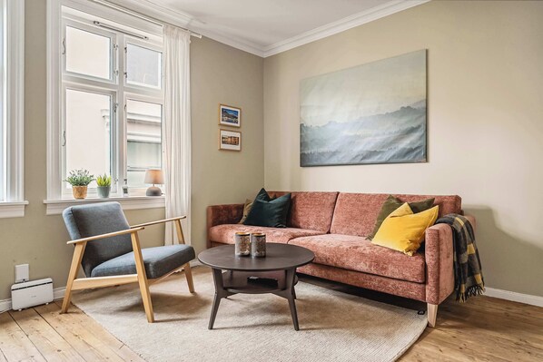 Relax on a stylish sofa in this sunlit space—perfect for unwinding after exploring Bergen.
