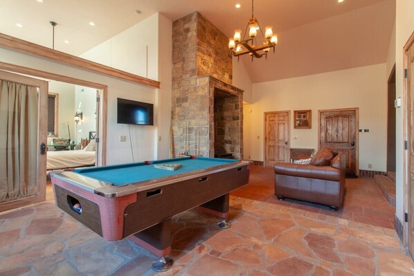 Step into this charming game room where you'll love challenging friends to a game of pool. With its cozy seating, flat-screen TV, and warm ambiance, this space is perfect for relaxation and entertainment after a day of adventure.