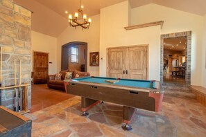 Enjoy the rustic elegance of this inviting living area, perfect for unwinding. You’ll appreciate the comfortable leather sofa, beautiful stone fireplace, and charming decor, making it an ideal spot for cozy evenings and lively conversations.