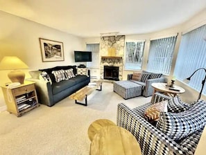 Living room with wood burning fireplace and sofa bed