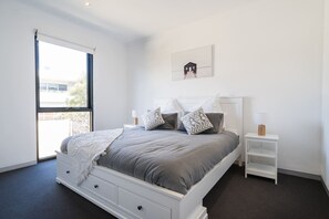 The spacious first bedroom features a queen-size bed with side tables and reading lamps, as well as built-in robes. 
