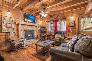 Living room with a fireplace and TV at A Beary Nice Cabin, a 2 bedroom cabin rental located in Pigeon Forge