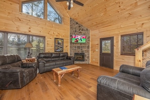 Vaulted living room with fireplace and TV at Bessy Bears Cabin, a 2 bedroom cabin rental located inGatlinburg